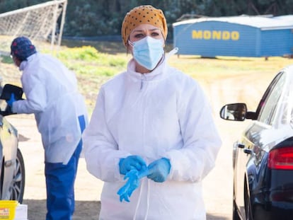 Una sanitaria entre dos filas de coches de personas mayores que esperan para ser vacunados con la vacuna de Pfizer en el exterior del Polideportivo Municipal, en Villafranca De Los Barros, Badajoz, Extremadura (España).