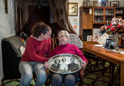 Pepita Barrón y Raquel Canovés, hija y nieta de José, con un montaje fotográfico de Pepita, su madre y su padre, en su casa de Aldaia (Valencia).