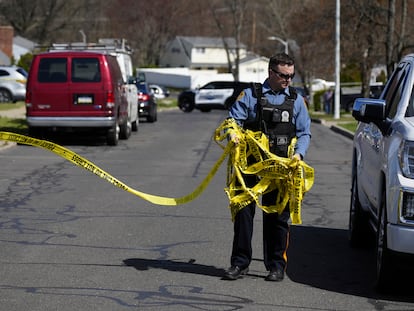 A police officer removes crime scene tape after a shooting was reported  in Levittown, Pa., Saturday, March 16, 2024.