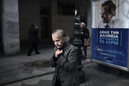 Una mujer pasa delante de un poster de la campaña electora del primer ministro Antonis Samaras.