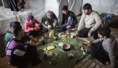 La familia yazidí de Arash Faramarzi, mientras almuerza en su tienda.