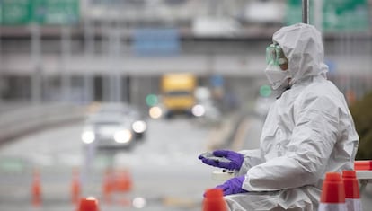 Seoul (Korea, Republic Of), 10/03/2020.- A medical staffer warms his hand with a hot pack amid the cold weather at a makeshift drive-thru (or drive-through) clinic in Seoul, South Korea, 10 March 2020, to check for coronavirus infections. (Corea del Sur, Seúl) EFE/EPA/YONHAP SOUTH KOREA OUT