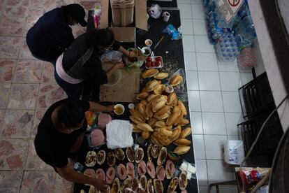 Un grupo de personas prepara alimentos en el albergue en el salón de eventos Kamakiri, en el Estado de México.