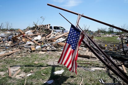 Una bandera ondea cerca de una casa dañada por un tornado,  en Greenfield, Iowa. 