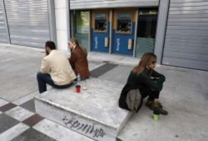 Empleados del Banco de Chipre, en el exterior de las oficinas de la entidad.