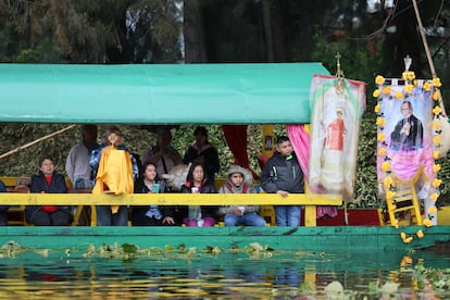 Fieles a bordo de una trajinera observan el paso de la reliquia de San Judas Tadeo por los canales de Xochimilco.