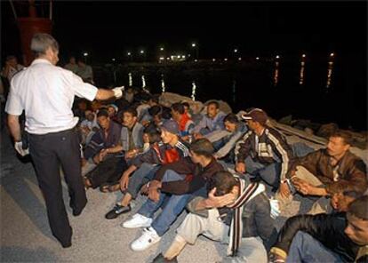 Un policía recuenta a un grupo de inmigrantes tras ser interceptada su patera al sur de Motril.