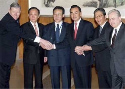 Los representantes de los seis países se saludan antes de comenzar las conversaciones en Pekín.