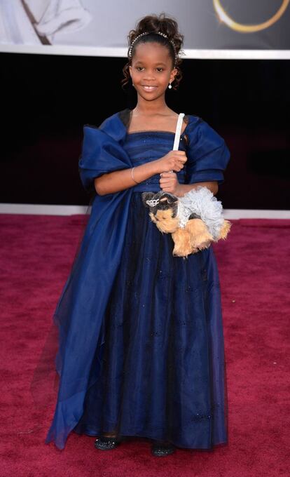 La niña protagonista de 'Bestias del sur salvaje', Quvenzhane Wallis, llega a la alfombra roja con su bolso con peluche de perrito (por lo visto, le da suerte) y un vestido azul noche de Armani Junior. Es la actriz más joven en optar al Oscar (tiene 9 años, 6 cuando grabó la película). Es también la primera vez que la línea infantil de Armani desfila por una alfombra roja.