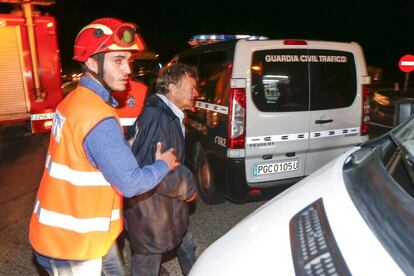 Los supervivientes del siniestro han quedado heridos de diversa gravedad. En la foto, dos voluntarios de protección civil acompañan a un pasajero.