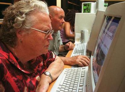 Dos vecinos de Jun (Granada) acceden a Internet en la sala de aprendizaje del pueblo.