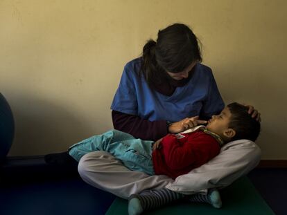 Elena López, voluntaria de la ONG Felicidad sin Fronteras, durante una terapia a uno de sus pacientes con hidrocefalia y parálisis cerebral.