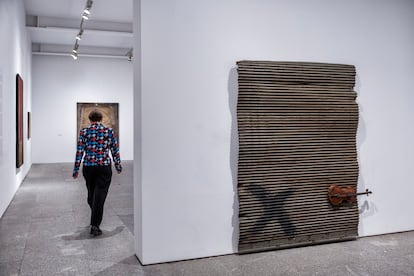 Una mujer pasa al lado de la obra 'Porta metàl·lica i violí', durante la presentación de la exposición dedicada a Antoni Tàpies. 