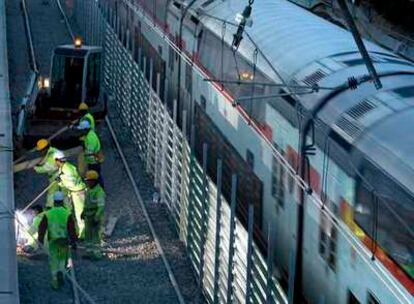 Un tren de Cercanías pasa al lado de las obras del AVE en Bellvitge.