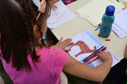 Una niña dibuja un ciervo de los pantanos.