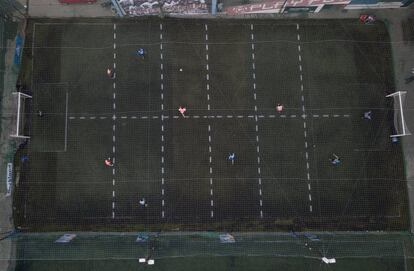 Varios hombres juegan al fútbol en un club loca, en Pergamino, Argentina. Para poder seguir jugando en medio de las restricciones del gobierno para frenar la propagación del nuevo coronavirus, el club dividió su campo de fútbol en 12 rectángulos para marcar áreas limitadas para cada jugador, con el fin de evitar el contacto físico.