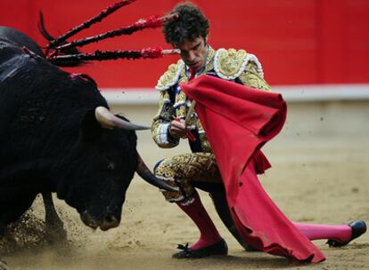 José Tomás realiza un pase de muleta de rodillas a uno de sus toros, en la plaza Monumental de Barcelona.