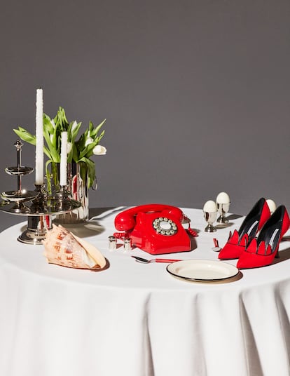 Una mesa puesta con elementos 'almodovarianos'. Los zapatos son Manolo Blahnik, del archivo de Elsa Fernández-Santos.