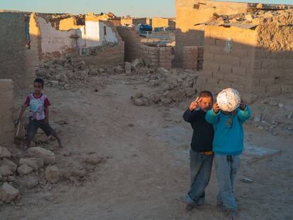 Tres niños saharauis, entre los escombros de casas destruidas.