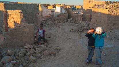 Tres niños saharauis, entre los escombros de casas destruidas.