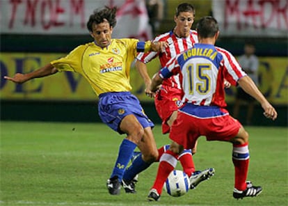 Quique Álvarez (izqda.) disputa el balón con Aguilera y Fernando Torres.