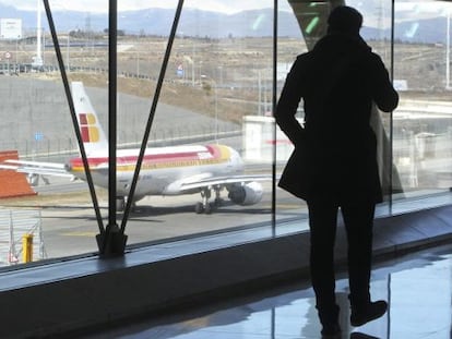Un pasajero observa un avión de Iberia en el aeropuerto de Barajas.