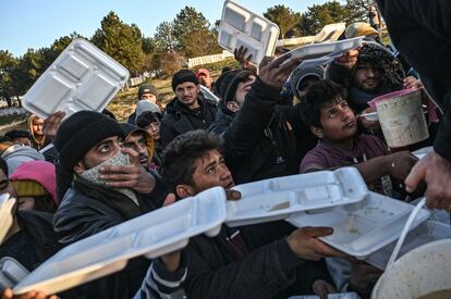 Un grupo de migrantes espera que le sirvan comida cerca de la ciudad de Edirne, en el noroeste de Turquía, antes de cruzar el río Meritsa en barco.