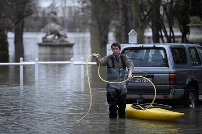 Un hombre lleva una canoa por una calle anegada cerca del río Sena en Villennes-sur-Seine, al oeste de París (Francia), el 29 de enero de 2018. 