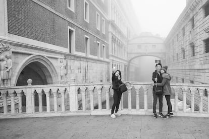 Unos turistas se fotografían con el Puente de los Suspiros de fondo.