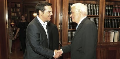 El primer ministro griego, Alexis Tsipras, estrecha la mano del presidente griego, Prokopis Pavlopoulos, tras anunciar su dimisi&oacute;n.