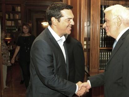 El primer ministro griego, Alexis Tsipras, estrecha la mano del presidente griego, Prokopis Pavlopoulos, tras anunciar su dimisi&oacute;n.