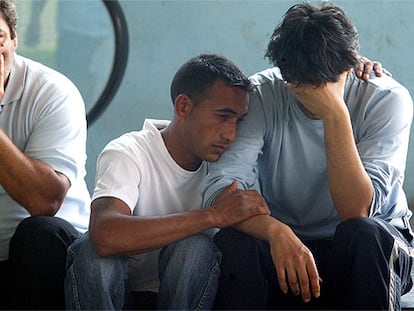 El padre del bebé (a la derecha) era ayer consolado por familiares y vecinos a las puertas del hospital.