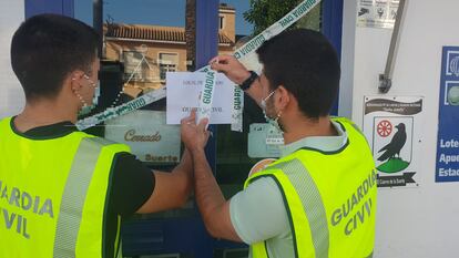 Agentes de la Guardia Civil precintan el establecimiento de lotería en El Cuervo que los Panecito adquirieron para blanquear.