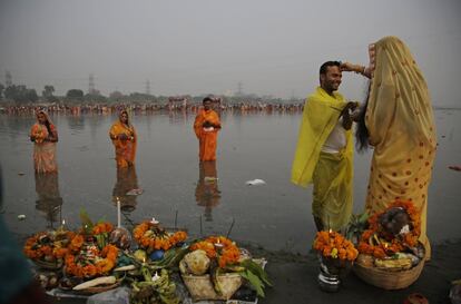 A Hindu devotee applies vermillion powder on the forehead of her husband as they perform rituals on the banks of the Yamuna River during Chhath Puja festival in New Delhi, India, Thursday, Oct. 26, 2017. During Chhath, an ancient Hindu festival, rituals are performed to thank the Sun god for sustaining life on earth. (AP Photo/Altaf Qadri)