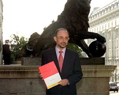 Cristóbal Montoro muestra uno de los libros del Presupuesto poco antes de entregarlos al Congreso.