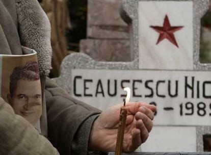 Un hombre sostiene una vela ante la tumba de Nicolae Ceausescu en Bucarest el pasado lunes.