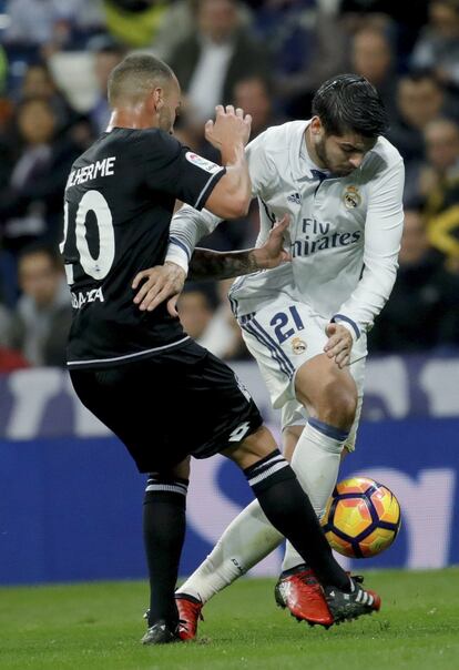 El delantero del Real Madrid Álvaro Morata, disputa un balón con el centrocampista brasileño del Deportivo Guilherme dos Santos durante el partido que enfrenta a Real Madrid y Deportivo.