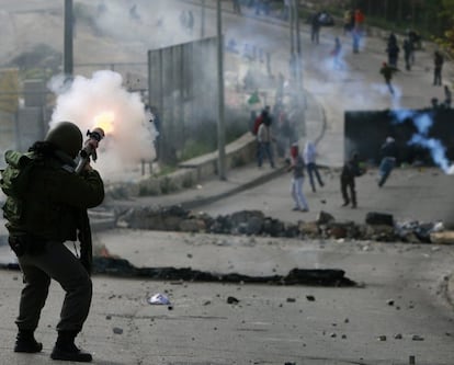 Un policía israelí lanza gases lacrimógenos contra palestinos que arrojan piedras, en Jerusalén Este.