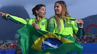 Martine e Kahena seguram a bandeira do Brasil no p&oacute;dio.