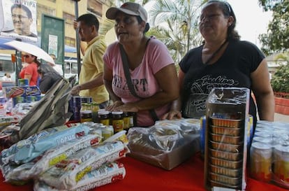 Un par de mujeres compran comida en un mercado estatal de Caracas.