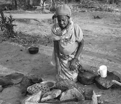 Leah Kipemba, de 80 años y acusada de brujería, enciende el fuego para calentar el agua. Por el continuo contacto con el humo, el sol y el polvo, tiene los ojos irritados y rojos. En Tanzania, según la creencia popular, eso es una característica identificativa.