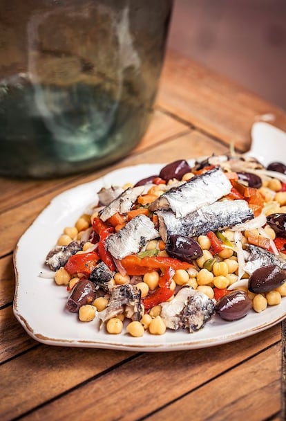 <p><i>Ingredientes </i></p><p> Para 4 personas: 750 gramos de garbanzos cocidos (de bote, de cocedero o refrigerados), 2 latas de sardinas en aceite de oliva, 2 cucharadas de alcaparras, 150 gramos de pimiento asado (morrón o en tiras), una cebolleta, ½ cucharadita de hojas tiernas de tomillo, 16 aceitunas negras tipo Aragón, vinagre de vino blanco, sal y pimienta. </p><p><i> Preparación</i></p><p> Si los garbanzos son de bote, lavarlos bajo el grifo en un colador para eliminar el líquido de conservación. Pelar la cebolleta y cortarla en tiras finas. Quitar las escamas, tripa y espinas –si tienen– a las sardinas y recuperar tres cucharadas del aceite de la conserva. Hacer una vinagreta con ese aceite, una cucharada de vinagre, sal, pimienta, el tomillo y las alcaparras. Mezclar con los pimientos cortados a tiras, los garbanzos y la cebolleta. Disponer por encima las sardinas y las aceitunas.</p>