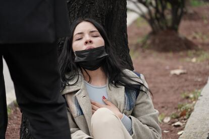 En Paseo de la Reforma, una mujer se sienta y recarga en un árbol, luego del temblor.