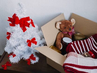 Cesta de donación preparada con ropa de abrigo, comida y juguetes para Navidad.