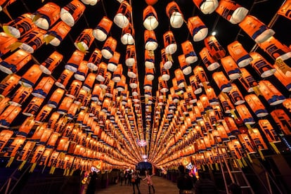 Visitantes passeiam por um túnel decorado com luminárias chinesas temáticas para o Ano Novo Lunar, em Xianxim, na China.