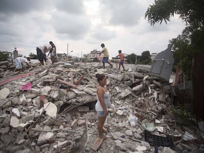 Survivors of Saturday's earthquake stand amid the ruins of their homes.