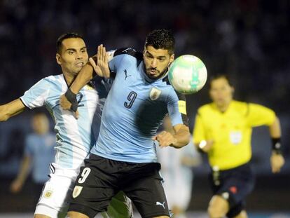 Gabriel Mercado y Luis Suárez disputan una pelota en el clásico.