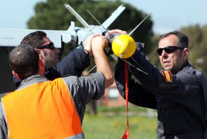 Personal del Ejército español manipulan un misil en el ala de un F-18, ayer en la base aérea de la isla italiana de Cerdeña.