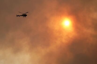 Un helicóptero de vigilancia sobrevuela una zona de incendios en Posada (Asturias).