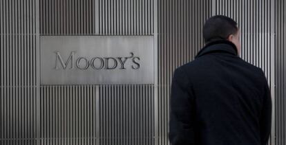 Un hombre ante un cartel de Moddy's en las oficinas de la empresa en Nueva York
